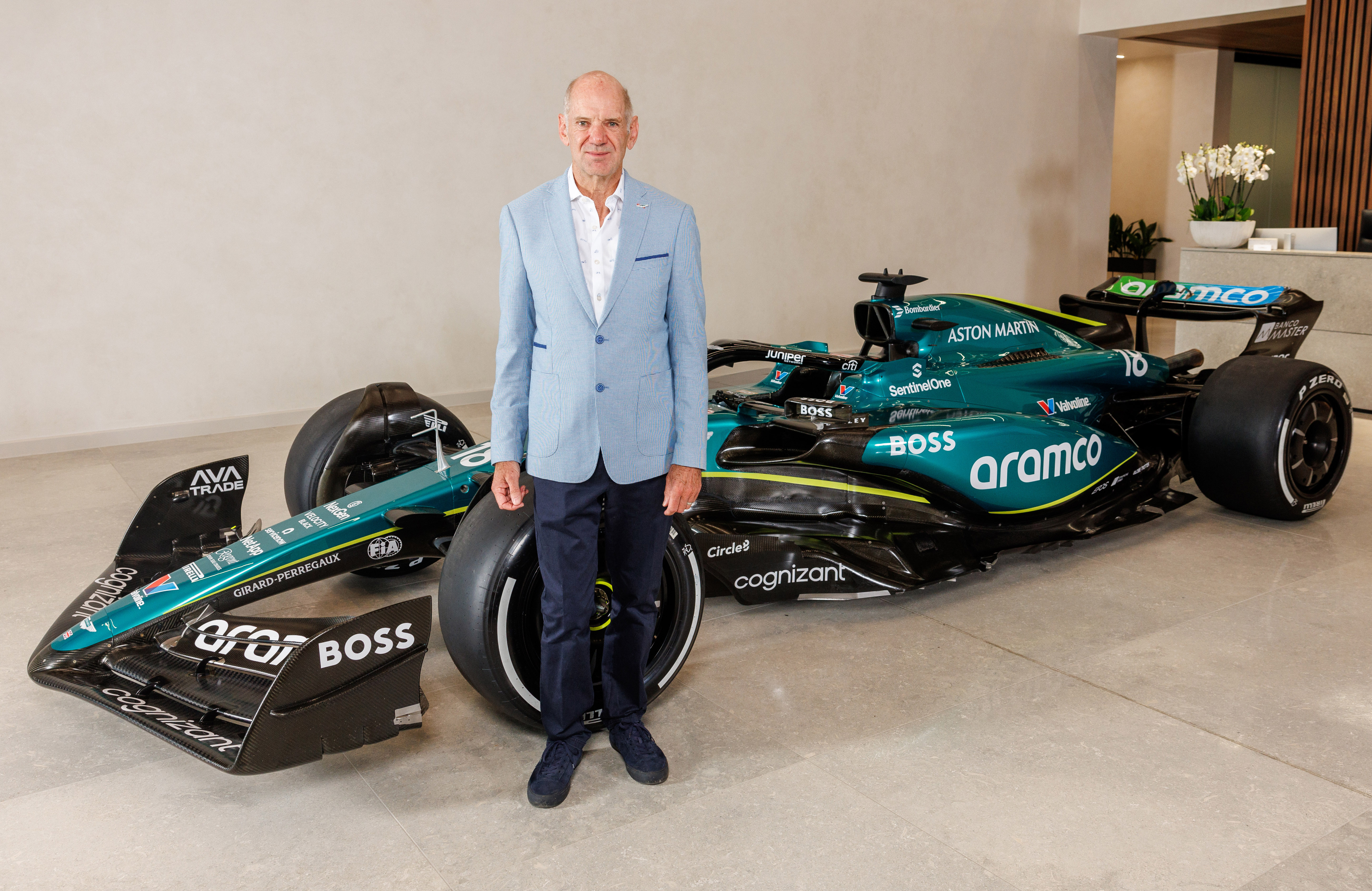 Wielki transfer Astona Martina w F1 - na zdjęciu Adrian Newey i Lawrence Stroll, którzy ścigają sobie dłoń na tle bolidu.